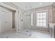 Modern bathroom with a large glass shower, tiled walls, and marble floors at 8045 Depford Way, Cumming, GA 30041