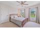 Bright bedroom with a ceiling fan, neutral carpet, and a large bed is illuminated by natural light at 8045 Depford Way, Cumming, GA 30041