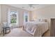 Bright bedroom with two windows, neutral carpet, ceiling fan and furniture is filled with natural light at 8045 Depford Way, Cumming, GA 30041