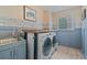 Well-organized laundry room features a washer, dryer, sink, countertop and stylish blue and wood accents at 8045 Depford Way, Cumming, GA 30041