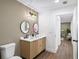 Modern bathroom boasts a double vanity, wood-look floors, stylish mirrors, and contemporary lighting fixture at 1111 Edgefield Sw Dr, Atlanta, GA 30310