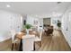 Dining area with an open-concept view into the kitchen and living room, featuring hardwood floors and a modern fireplace at 1111 Edgefield Sw Dr, Atlanta, GA 30310
