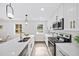 Modern kitchen boasts white cabinets, quartz countertops, stainless steel appliances, and stylish pendant lighting at 1111 Edgefield Sw Dr, Atlanta, GA 30310