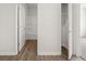 Hallway with wood floors leads to a white bathroom and closet with white doors at 408 Oak View Ln, Dallas, GA 30157