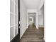 Inviting hallway with wood-look flooring, white trim and neutral paint leads to rooms filled with natural light at 408 Oak View Ln, Dallas, GA 30157