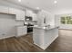Stylish kitchen features white cabinets, stainless appliances, granite counters, and wood-look flooring at 408 Oak View Ln, Dallas, GA 30157