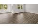 Bright living room features two windows and doors with wood-look flooring throughout the space at 408 Oak View Ln, Dallas, GA 30157