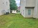 Side yard featuring green grass, AC units, and residential landscape at 4925 Locherby Dr, Fairburn, GA 30213