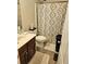 Bathroom featuring decorative shower curtain, neutral walls, and essential amenities at 4925 Locherby Dr, Fairburn, GA 30213