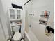 Bathroom features a toilet with a cabinet above it and a tub with shower head at 4925 Locherby Dr, Fairburn, GA 30213