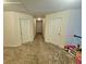 Upstairs hallway with neutral carpet and adjacent bedroom doors at 4925 Locherby Dr, Fairburn, GA 30213