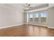 Spacious primary bedroom boasts hardwood floors, tray ceiling, and large windows at 1609 Tielman Way, Snellville, GA 30078