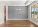 Stylish dining room with hardwood floors, decorative wall paneling, and a modern chandelier at 1609 Tielman Way, Snellville, GA 30078