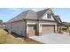 Spacious three-car garage with brick and siding accents and a concrete driveway at 1609 Tielman Way, Snellville, GA 30078
