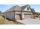 Exterior view of a three car garage with carriage doors and brick accents at 1609 Tielman Way, Snellville, GA 30078