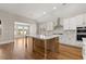 Modern kitchen features large island, stainless steel appliances and hardwood floors with seamless cooking experience at 1609 Tielman Way, Snellville, GA 30078