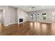 Open-concept living room with hardwood floors, fireplace, and french doors to outdoor space at 1609 Tielman Way, Snellville, GA 30078