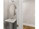 Chic powder room featuring a pedestal sink, modern mirror, and neutral color palette for a clean, elegant look at 1609 Tielman Way, Snellville, GA 30078