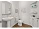 A simple powder room featuring a pedestal sink, framed artwork, and wood-look floors at 3 Hundley Ln, Roswell, GA 30076