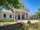 Harlow Hall features a covered porch, with a seating area, surrounded by manicured landscaping and lush greenery at 3 Hundley Ln, Roswell, GA 30076