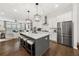 Open kitchen with island, stainless steel appliances, pendant lighting, flowing into living area at 3 Hundley Ln, Roswell, GA 30076