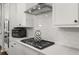 Modern kitchen boasts stainless steel appliances, sleek white cabinets, and a subway tile backsplash at 3 Hundley Ln, Roswell, GA 30076