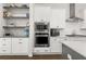 Well-appointed kitchen with built-in stainless steel microwave, oven, and stylish floating shelves at 3 Hundley Ln, Roswell, GA 30076
