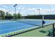 Well-maintained tennis court featuring vibrant blue and green surfaces, complete with net and fencing at 3 Hundley Ln, Roswell, GA 30076