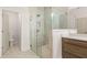 Modern bathroom featuring an elegant glass shower, marble walls, and stylish wooden cabinetry at 3772 Tielman St, Snellville, GA 30078