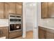 Gourmet kitchen showcases stainless steel double ovens and custom wood cabinets, plus convenient walk-in pantry at 3772 Tielman St, Snellville, GA 30078