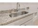 Close-up view of a laundry room sink with granite countertop and white cabinets at 3772 Tielman St, Snellville, GA 30078