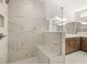 Luxurious shower with marble tile surround, glass enclosure, built-in bench, and modern fixtures at 3772 Tielman St, Snellville, GA 30078