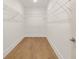 Empty walk-in closet space with installed shelving and hardwood floors at 3772 Tielman St, Snellville, GA 30078