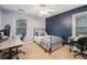Comfortable bedroom featuring a blue accent wall, natural light, and home office setup at 3824 N Cooper Lake Se Rd, Smyrna, GA 30082