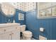 Stylish powder room featuring blue wainscoting, patterned wallpaper, and a modern sink at 3824 N Cooper Lake Se Rd, Smyrna, GA 30082