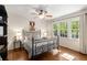 A bright bedroom features hardwood floors, a ceiling fan and large windows at 6990 Brandon Mill Nw Rd, Atlanta, GA 30328