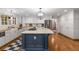 Open kitchen featuring an island with cooktop, granite countertops, stainless appliances, and hardwood floors at 6990 Brandon Mill Nw Rd, Atlanta, GA 30328