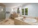 Luxurious main bathroom with a soaking tub, double vanity, and glass-enclosed shower, creating a spa-like retreat at 6990 Brandon Mill Nw Rd, Atlanta, GA 30328