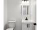 Compact bathroom featuring a toilet and vanity with a white sink and dark fixtures at 326 Oakview Way, Canton, GA 30114