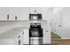 Well-lit kitchen with stainless steel appliances, white cabinets, quartz countertops, and hardwood flooring at 326 Oakview Way, Canton, GA 30114