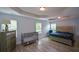 A spacious bedroom featuring hardwood floors, a tray ceiling, and two windows at 917 Revere Way, Hampton, GA 30228