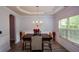 Formal dining area showcases wainscoting, a chandelier, and a large window with natural light at 917 Revere Way, Hampton, GA 30228
