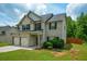 Charming home boasts a brick and siding exterior, complemented by a lush green lawn and blue skies at 917 Revere Way, Hampton, GA 30228