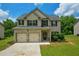 Charming two-story home features a brick facade, two-car garage and lush green lawn at 917 Revere Way, Hampton, GA 30228