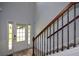 Bright foyer features wood floors, elegant staircase with iron spindles, and natural light at 917 Revere Way, Hampton, GA 30228