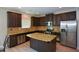 Spacious kitchen features dark cabinets, granite countertops, stainless steel appliances and island at 917 Revere Way, Hampton, GA 30228