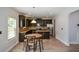 Open-concept kitchen with dark wood cabinets, granite counters, and stainless steel appliances at 917 Revere Way, Hampton, GA 30228