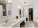 Bright bathroom featuring double vanity, quartz countertop, walk-in closet, and decorative framed mirrors at 135 Clubhouse Nw Dr, Kennesaw, GA 30144
