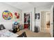 This bedroom has a colorful rug, a comfortable bed, and a closet filled with clothing and toys at 135 Clubhouse Nw Dr, Kennesaw, GA 30144