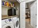 Laundry room with modern washer and dryer, granite countertop, and wire shelving, adjacent to bedroom at 135 Clubhouse Nw Dr, Kennesaw, GA 30144